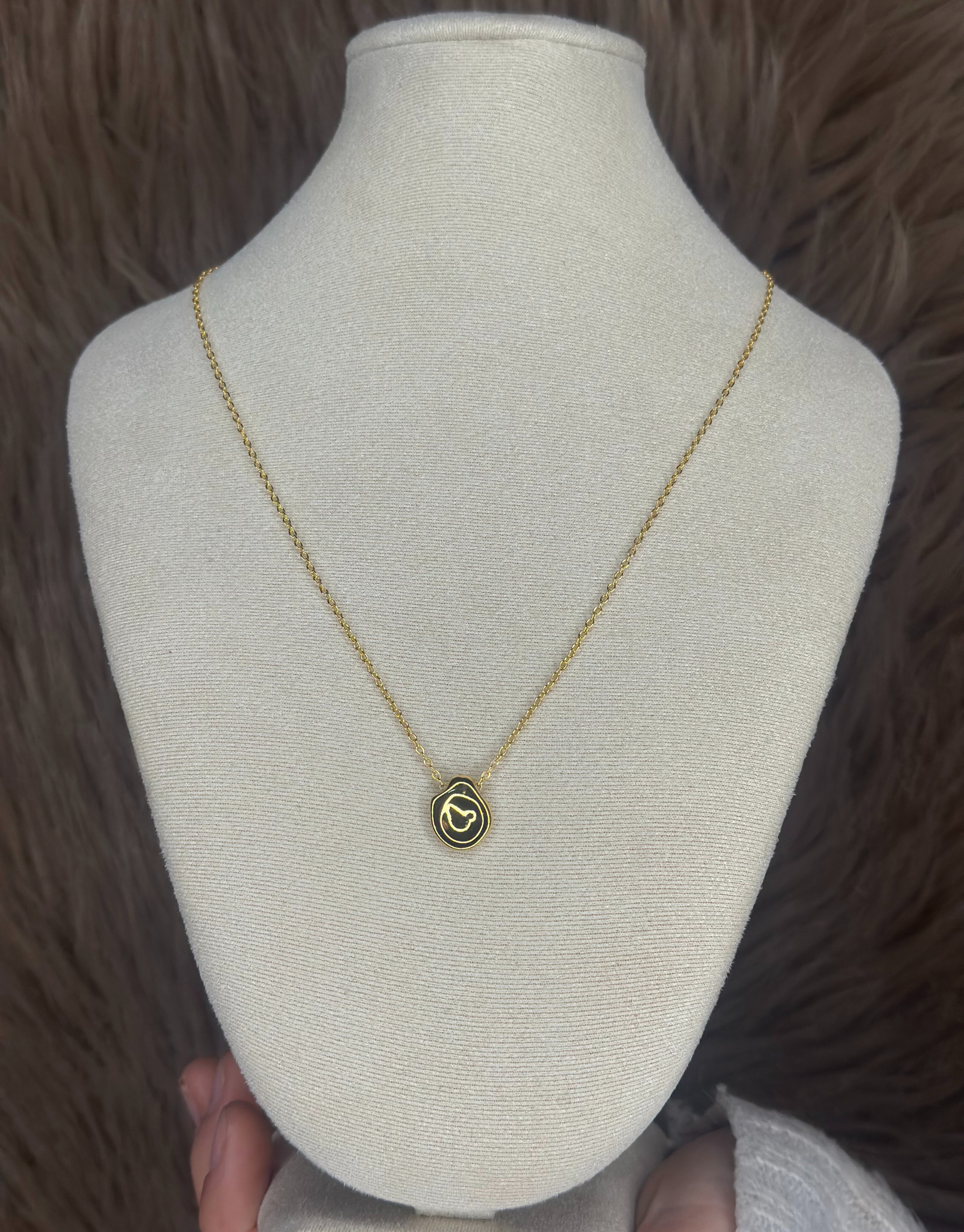 Smuk guld halskæde med abstrakt vedhæng.