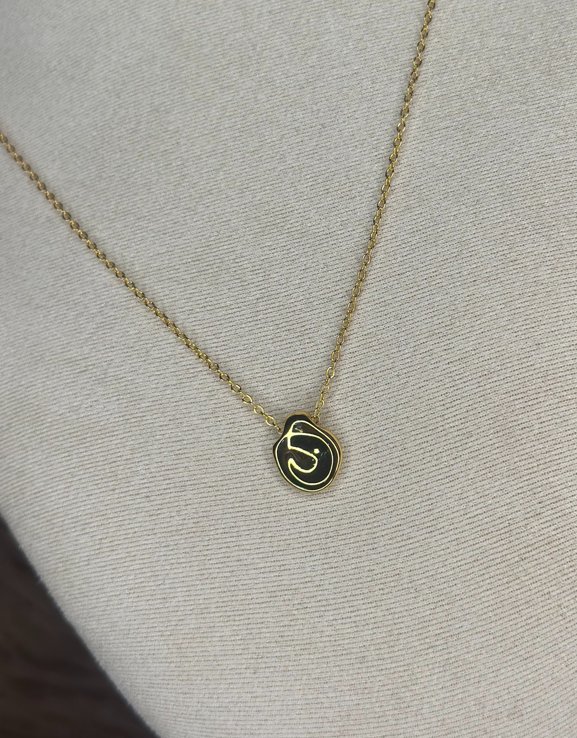 Smuk guld halskæde med abstrakt vedhæng.