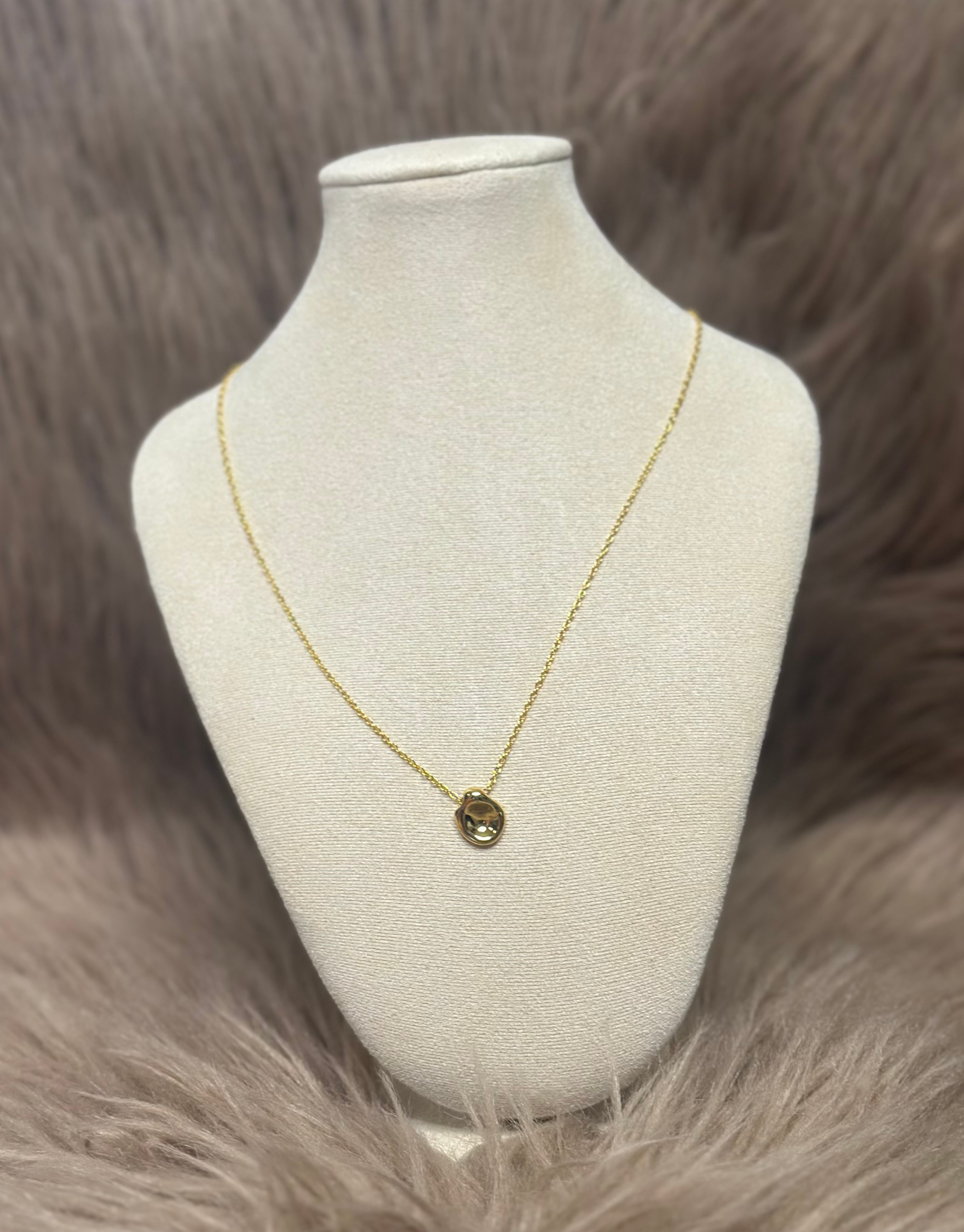 Smuk guld halskæde med abstrakt vedhæng.