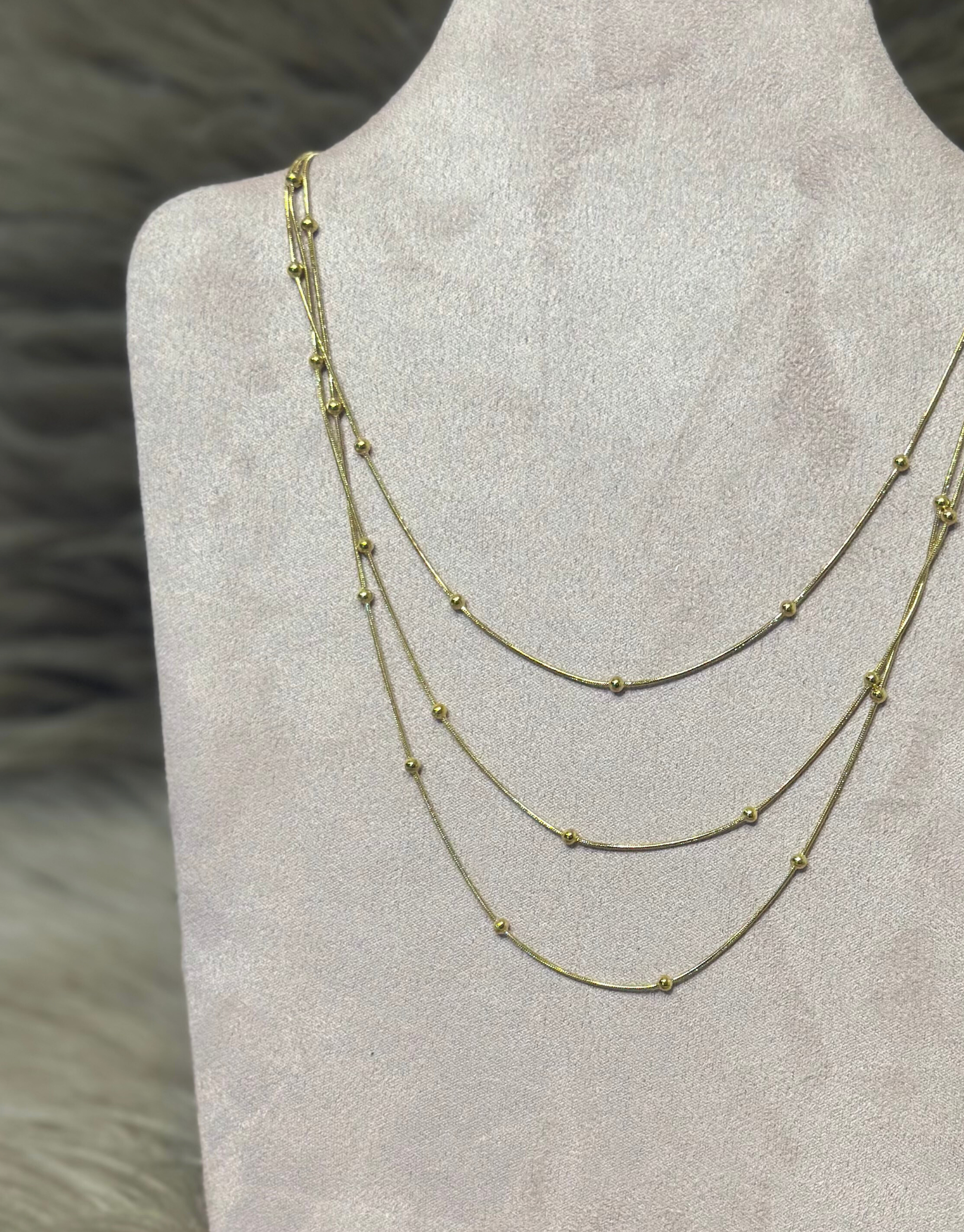 Smuk halskæde i guld med tre kæder med flotte detaljer.