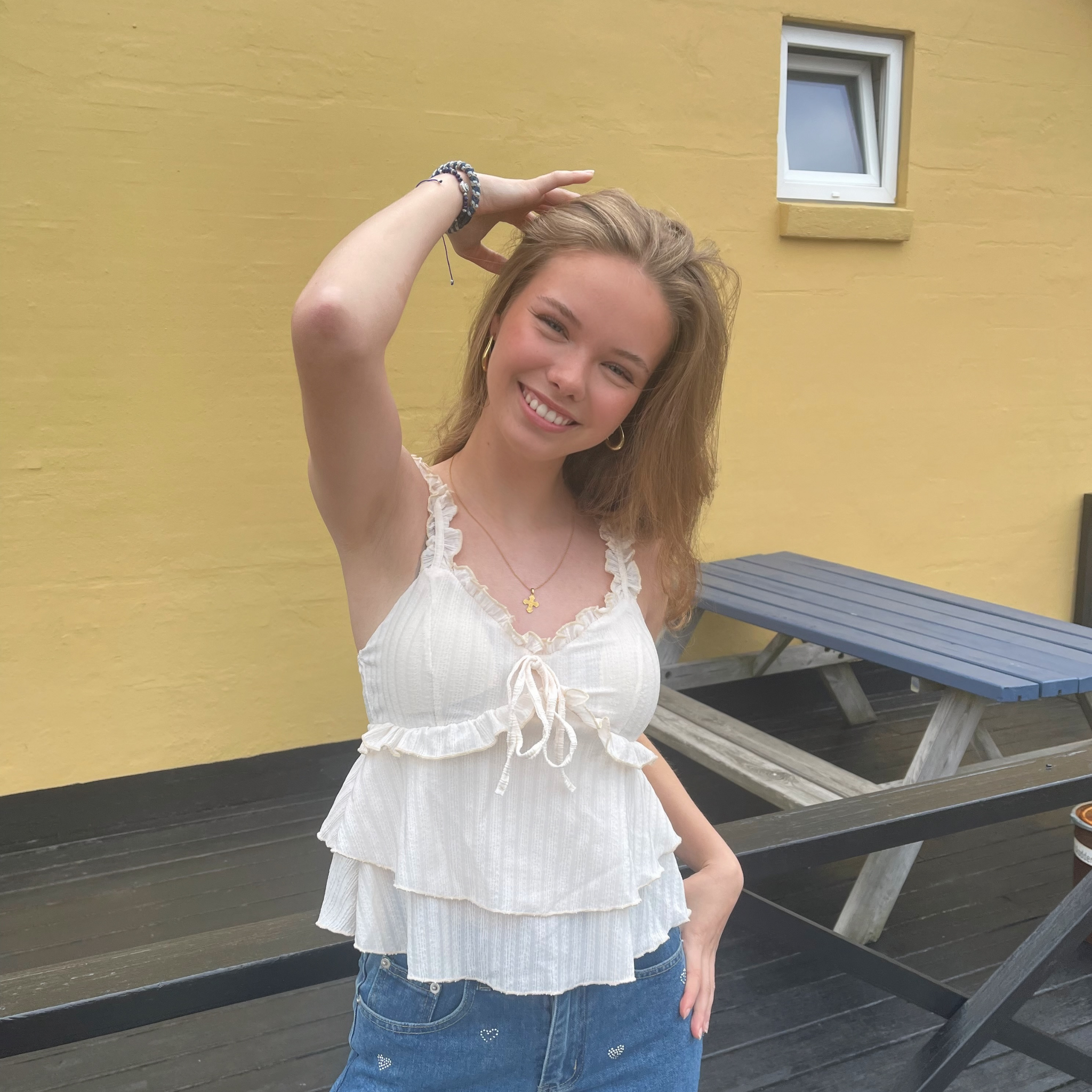 Smuk top med v-udskæring, blondedetaljer og sløjfe ved brystet.