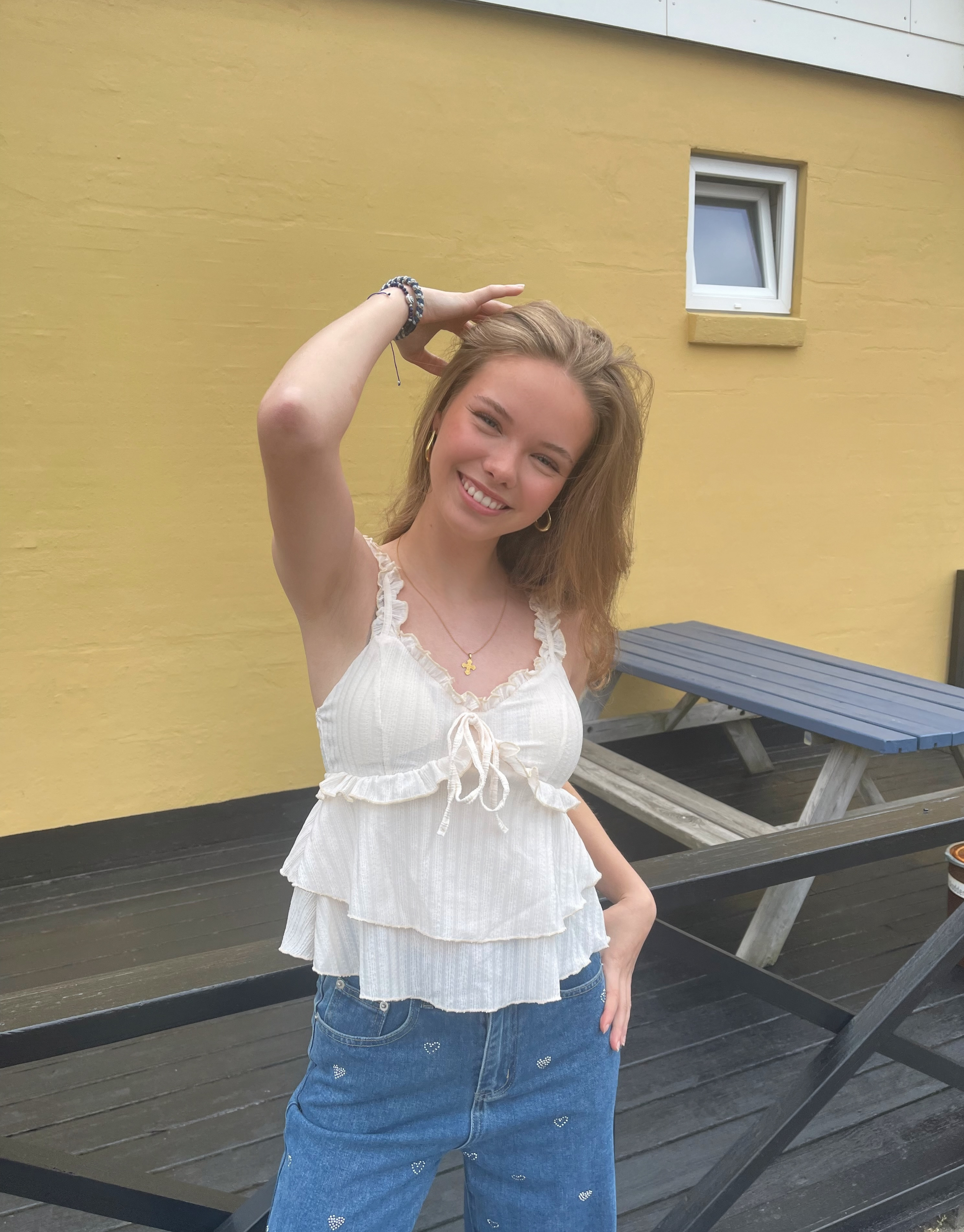 Smuk top med v-udskæring, blondedetaljer og sløjfe ved brystet.