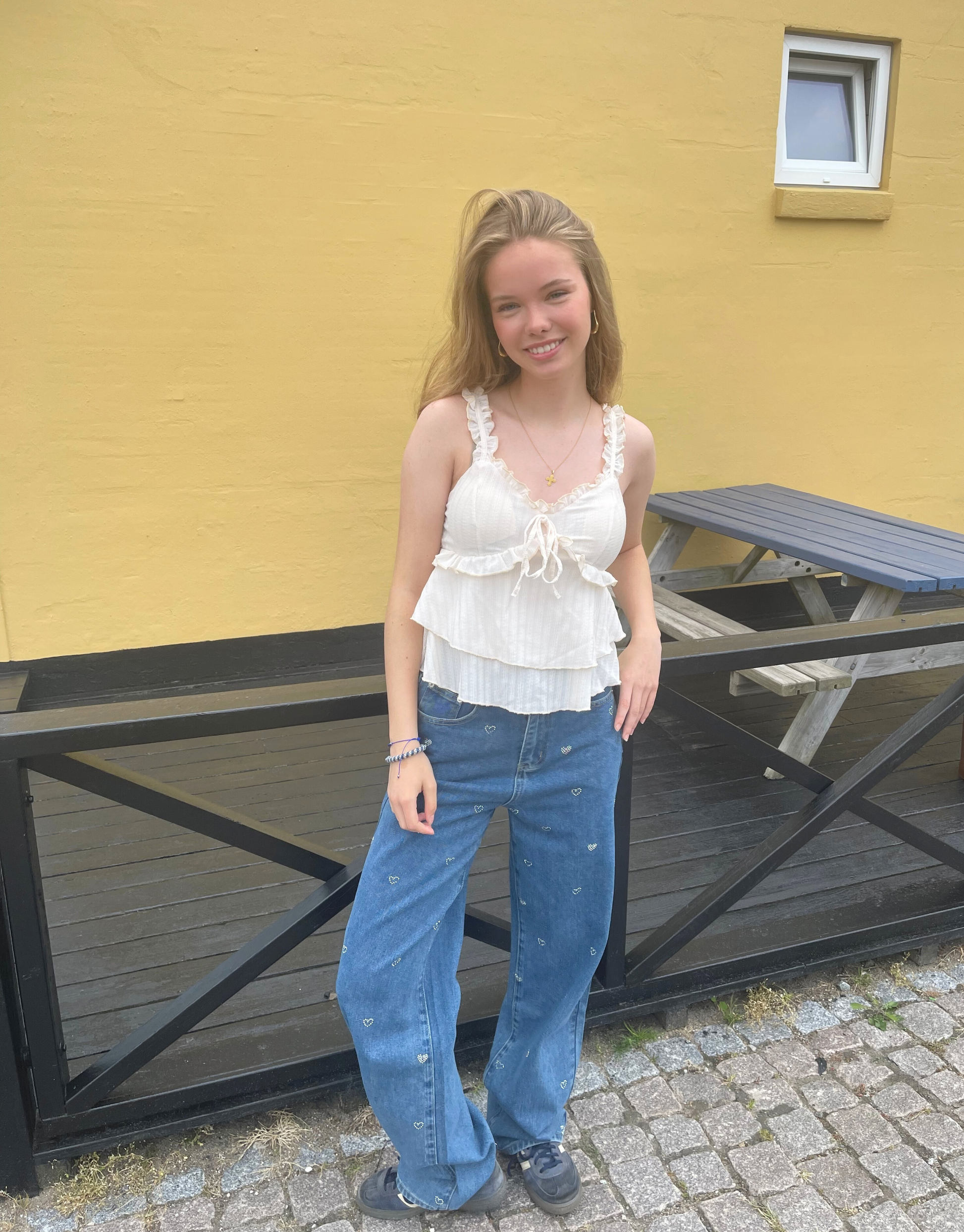 Smuk top med v-udskæring, blondedetaljer og sløjfe ved brystet.