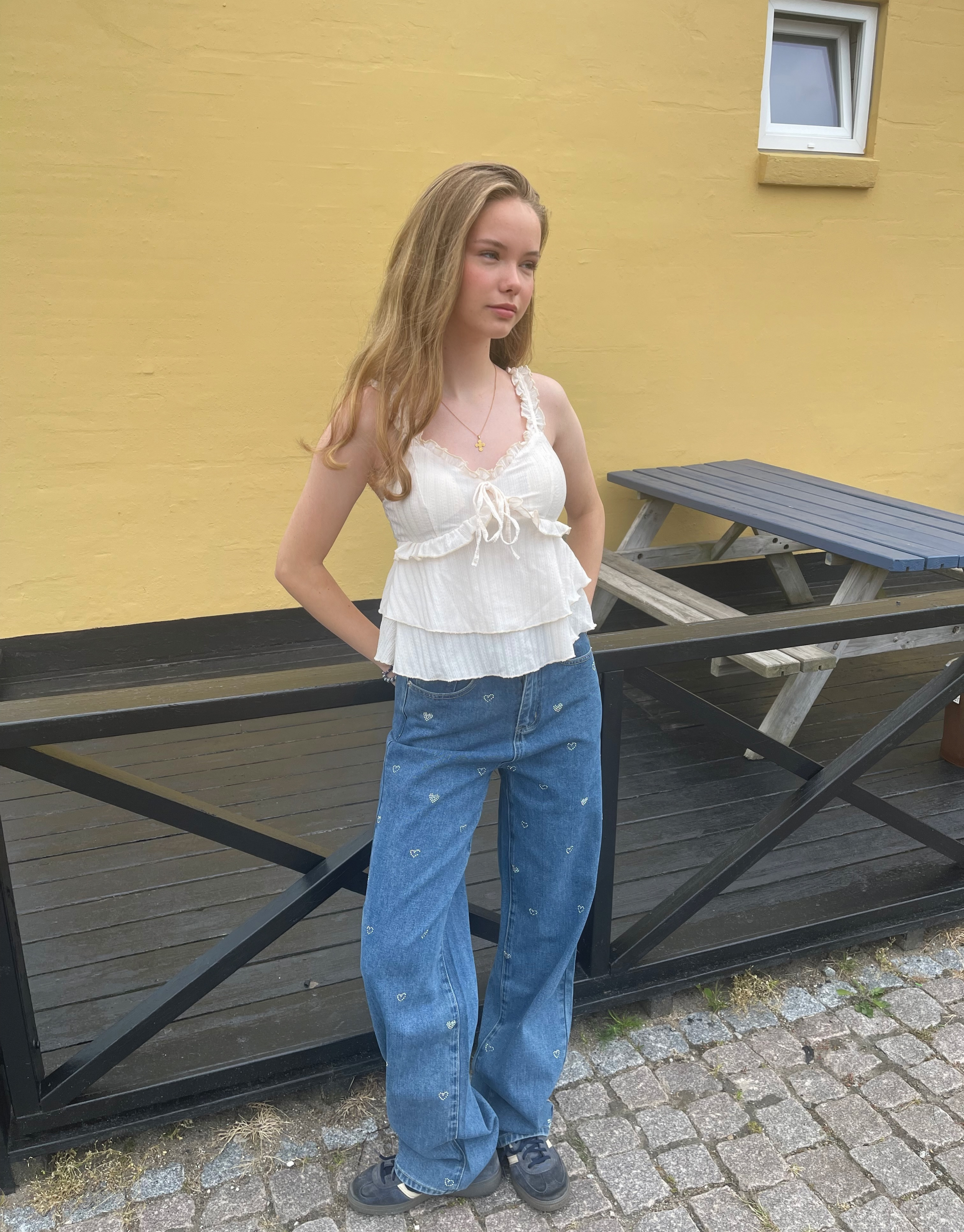 Smuk top med v-udskæring, blondedetaljer og sløjfe ved brystet.