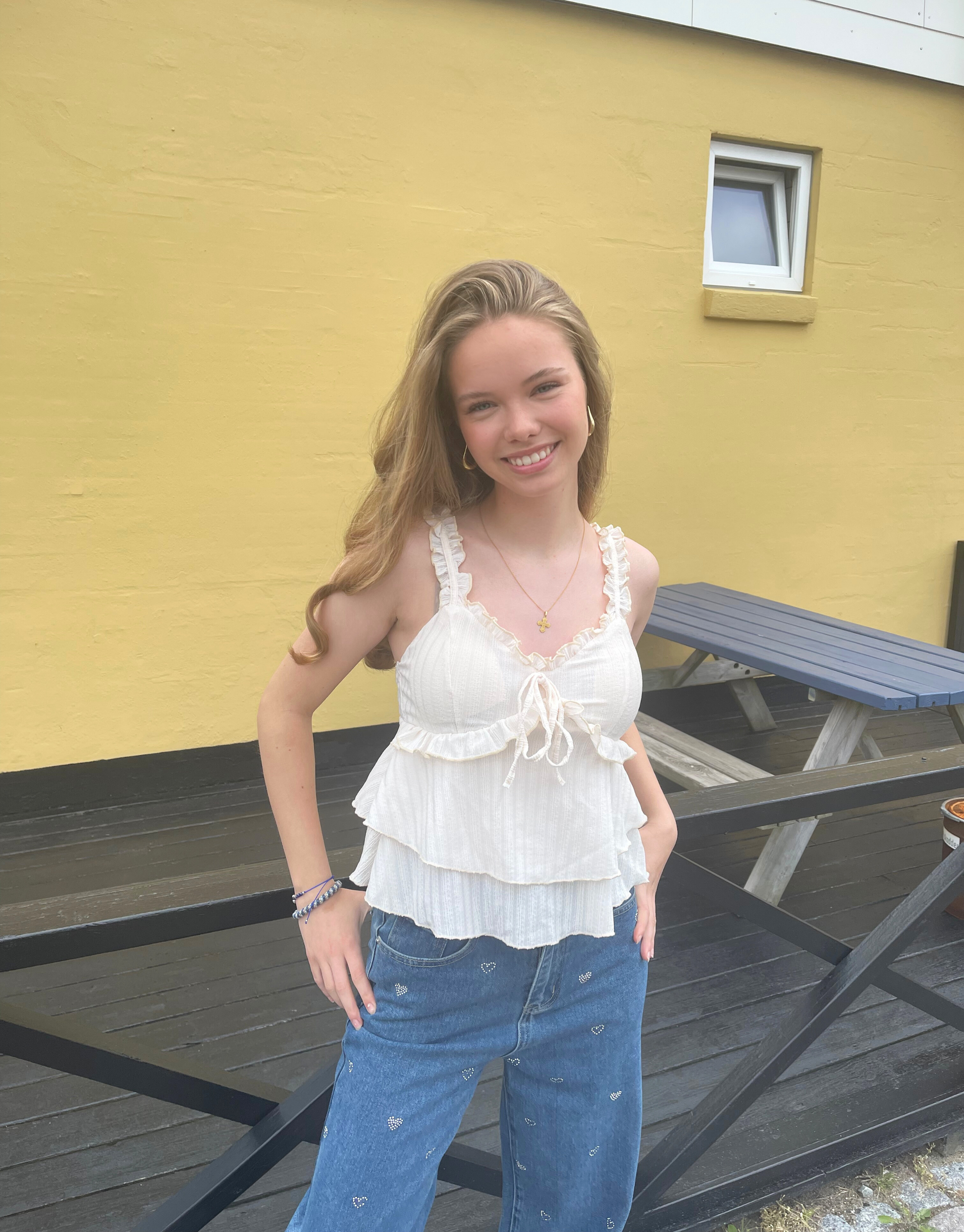 Smuk top med v-udskæring, blondedetaljer og sløjfe ved brystet.