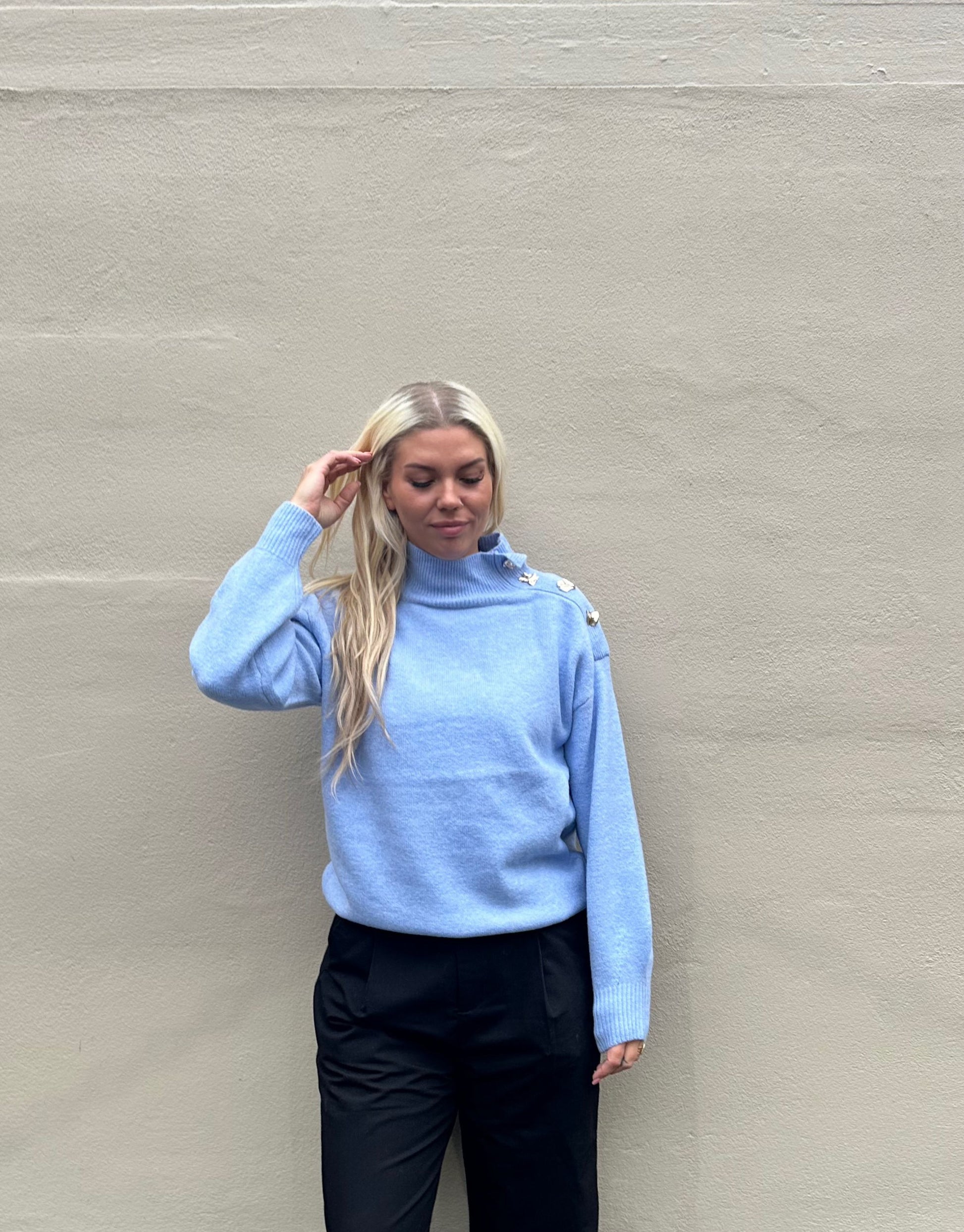 Lækker varm strik i den flotteste lyseblå farve med guld detaljer ved halsen.