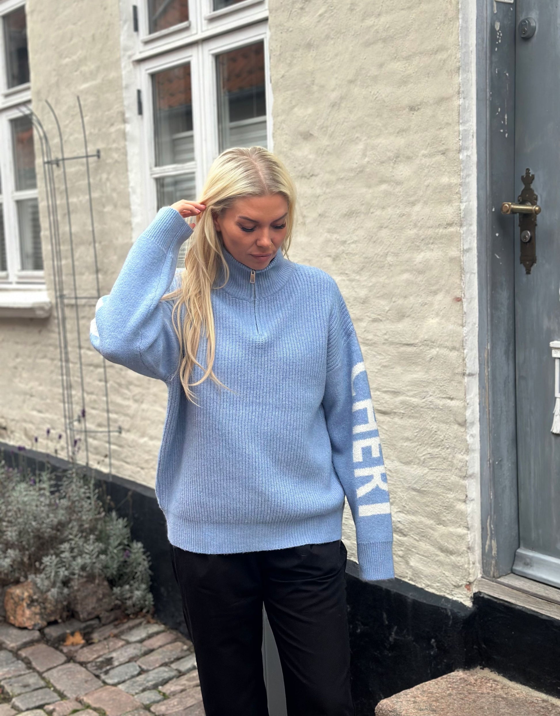 Lækker højhalset strik med Mon Cheri tekst på ærmerne.