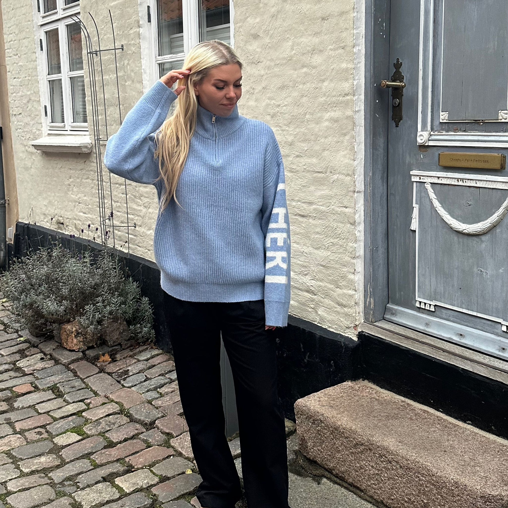 Lækker højhalset strik med Mon Cheri tekst på ærmerne.