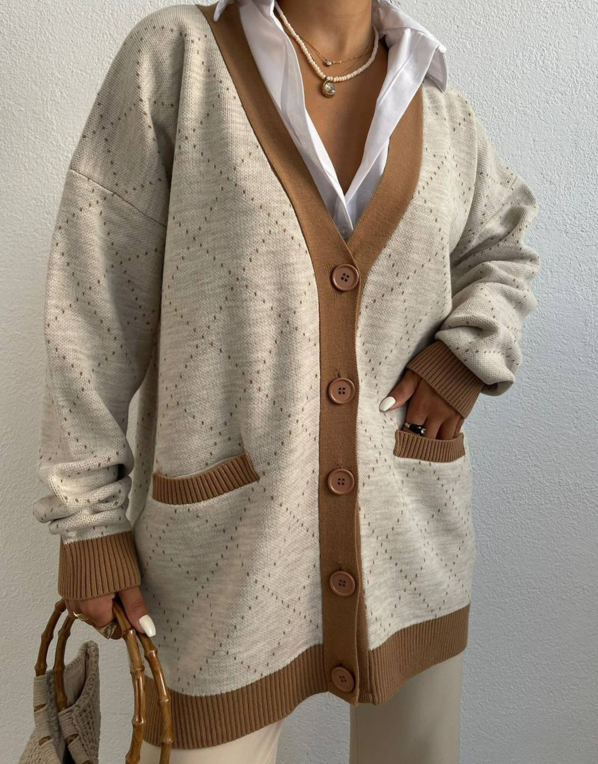 Sadia cardigan i beige med brune detaljer.  Skøn cardigan med V-udskæring, knapper og lommer.  Blød og komfortabel cardigan med flotte detaljer.  Om produktet Fit: Regular fit Materiale: 45% polyester, 30% uld, 20% akryl, 5% nylon Finvask ved max 30˚C