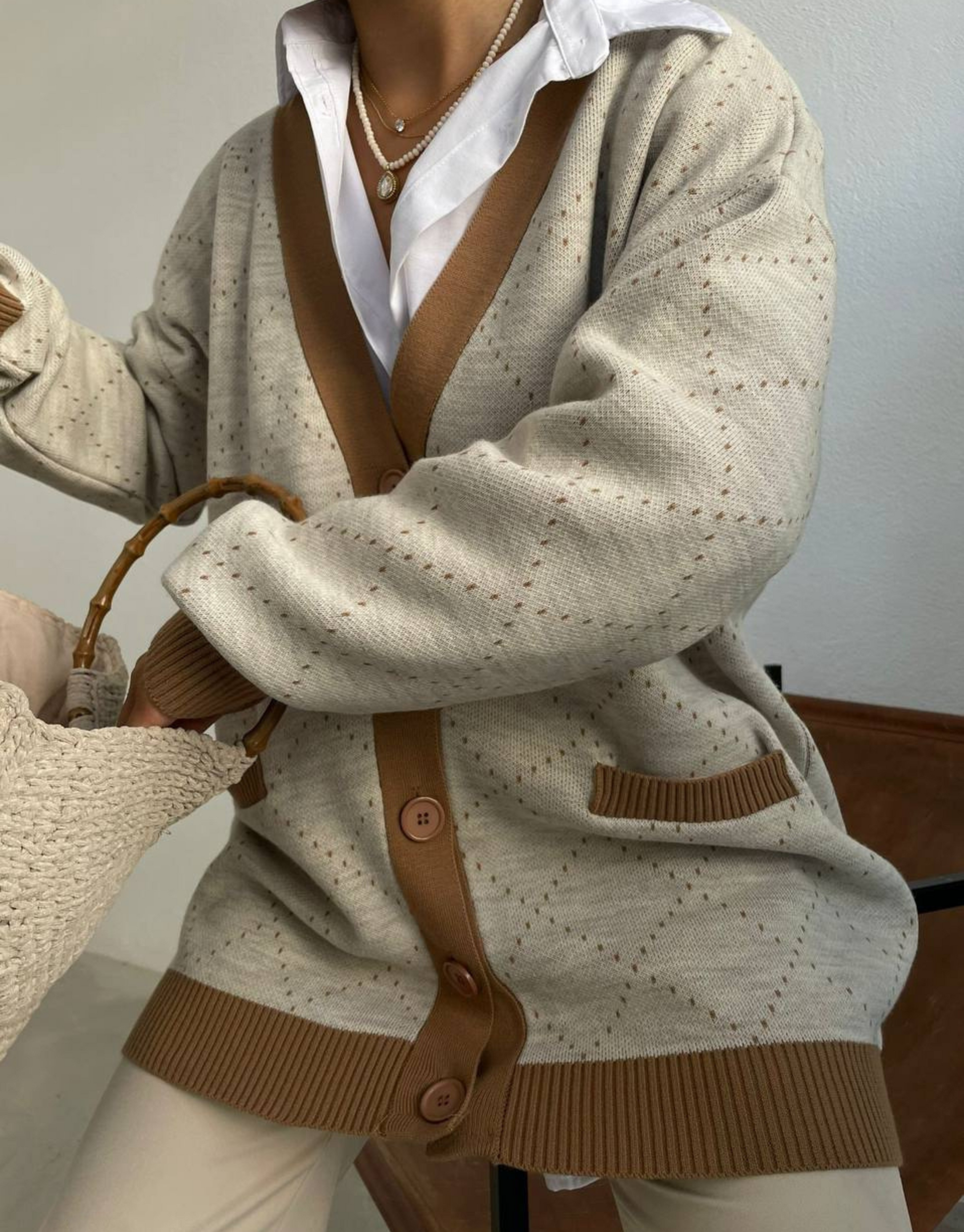 Sadia cardigan i beige med brune detaljer.  Skøn cardigan med V-udskæring, knapper og lommer.  Blød og komfortabel cardigan med flotte detaljer.  Om produktet Fit: Regular fit Materiale: 45% polyester, 30% uld, 20% akryl, 5% nylon Finvask ved max 30˚C